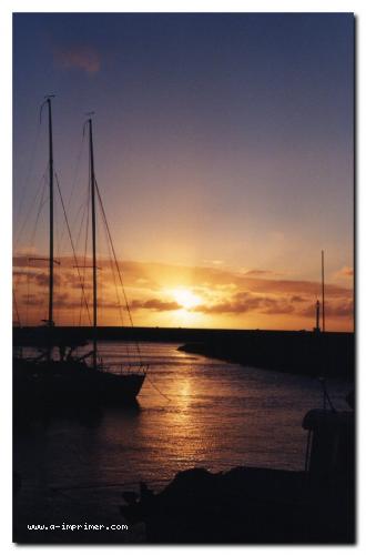 Carte postale de bateaux devant un coucher de soleil  la Runion.
