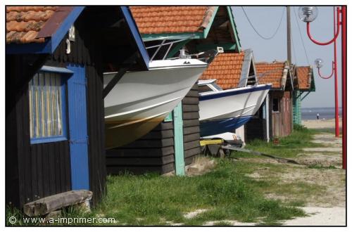 Carte postale de bateaux dans leurs cabanes.